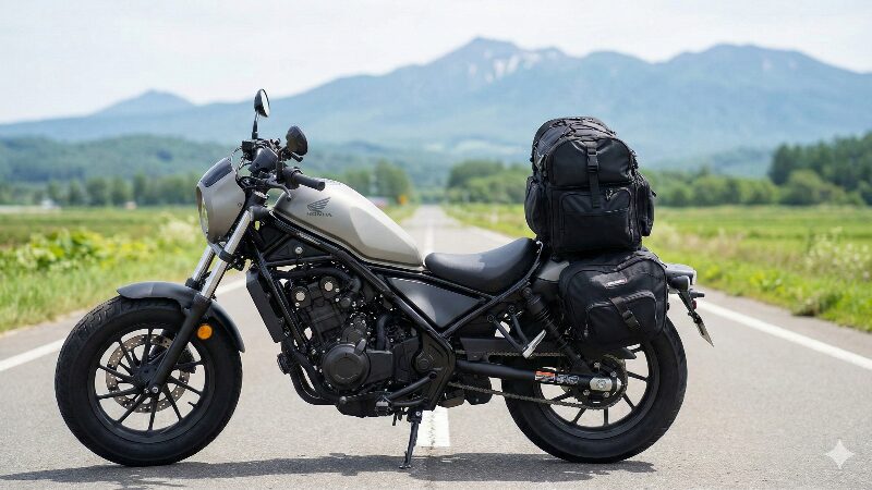 北海道のような雄大な道を背景に、サイドバッグは控えめにしてリアシートに大きなキャンプ用シートバッグを積載した旅仕様のレブル